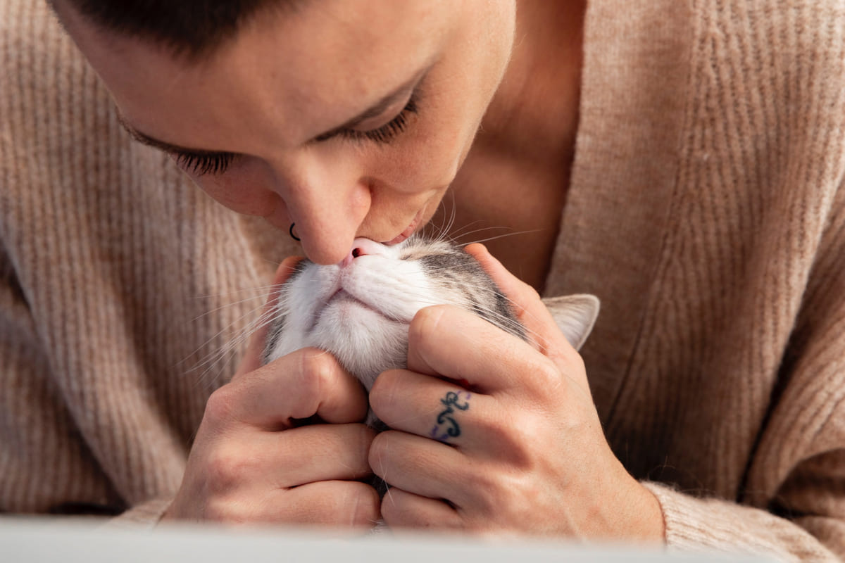 Woman kissing her cat on the nose