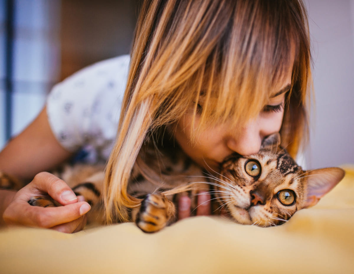 Woman sniffing a Bengal cat