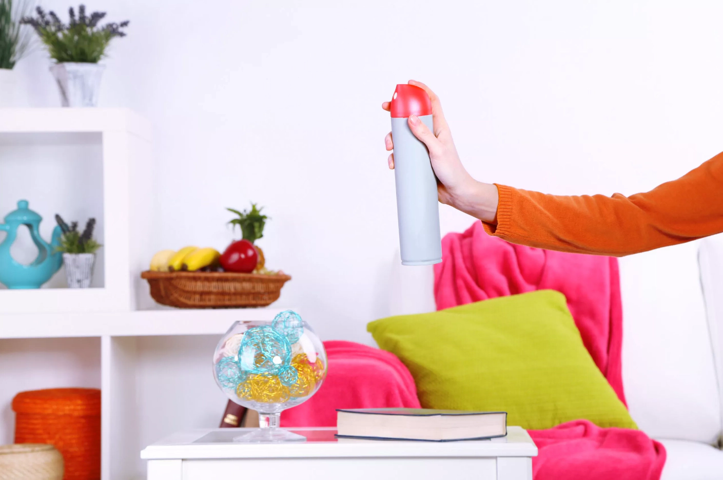 A person holding room air freshener in the air
